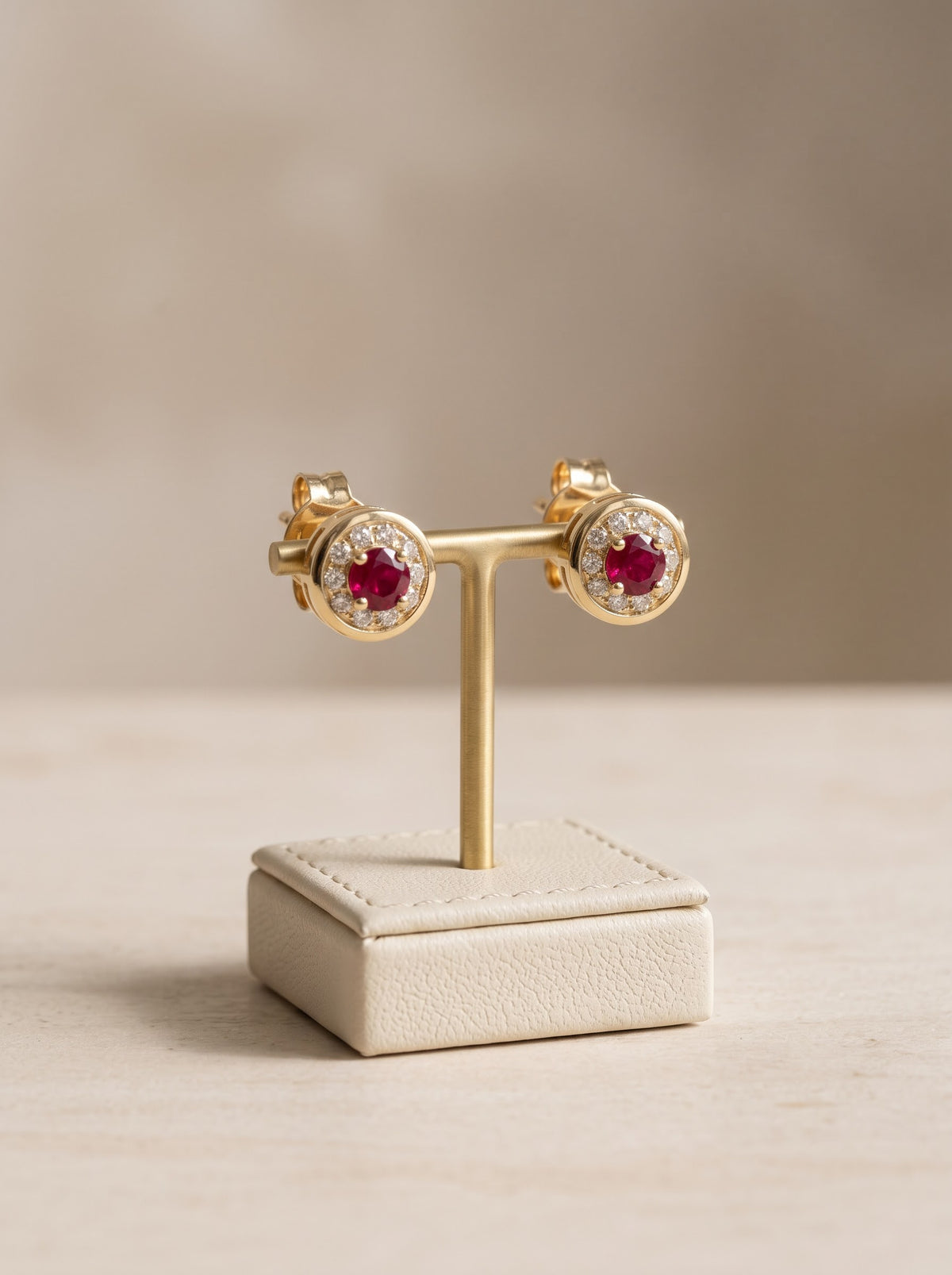 Vintage ruby and diamond halo stud earrings in 18ct yellow gold, on stand