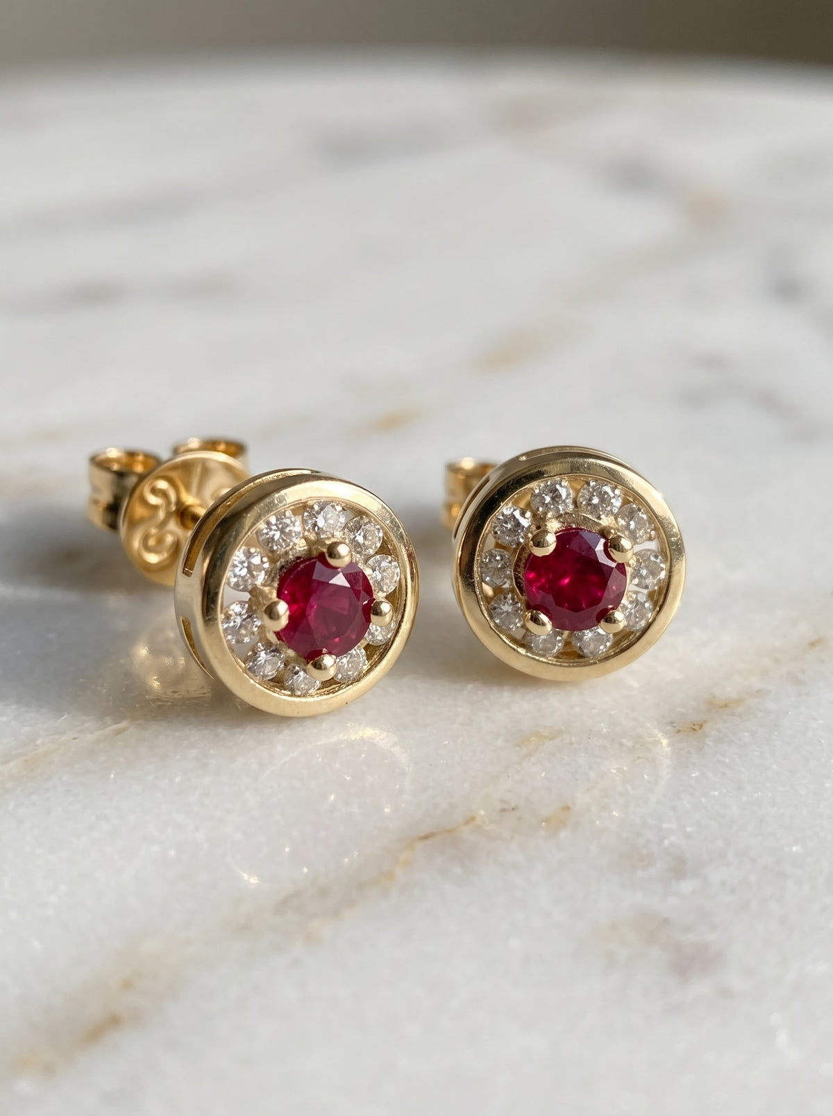 Close-up of ruby and diamond halo stud earrings