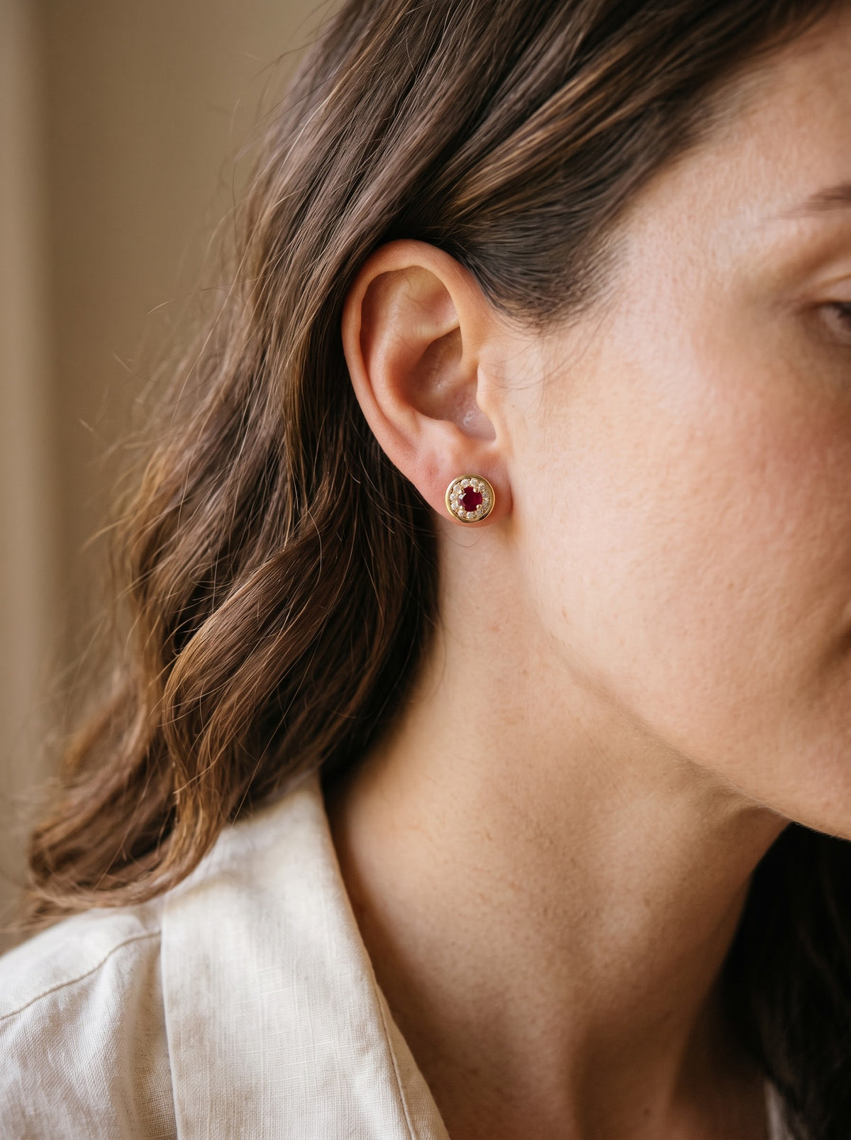Ruby and diamond stud earring being worn